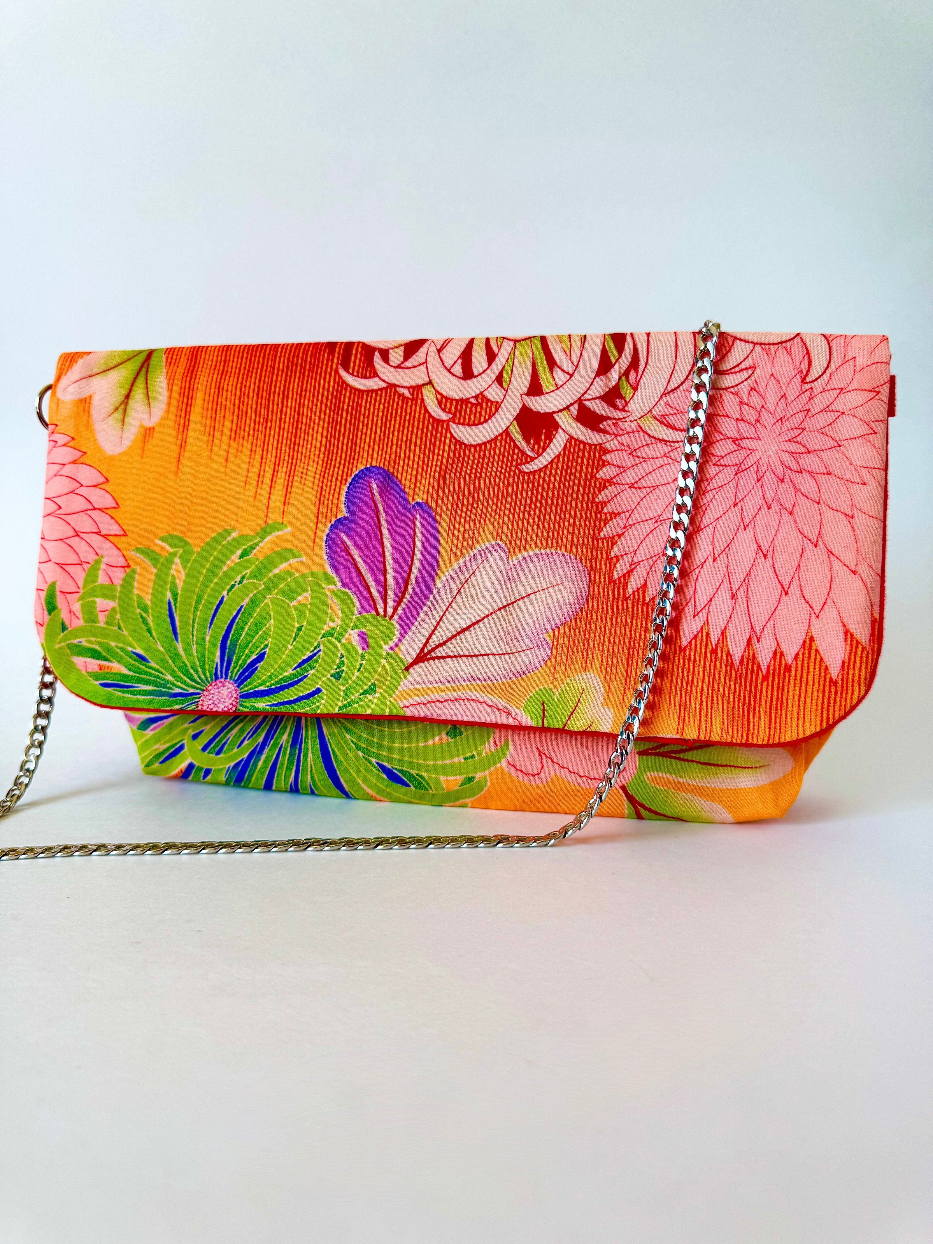 Orange and yellow fold over style bag made from upcycled kimono fabric, featuring a summer floral pattern.