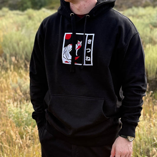 Model wearing Kitsune hoodie standing in nature, arms at the sides, showcasing front embroidery design.