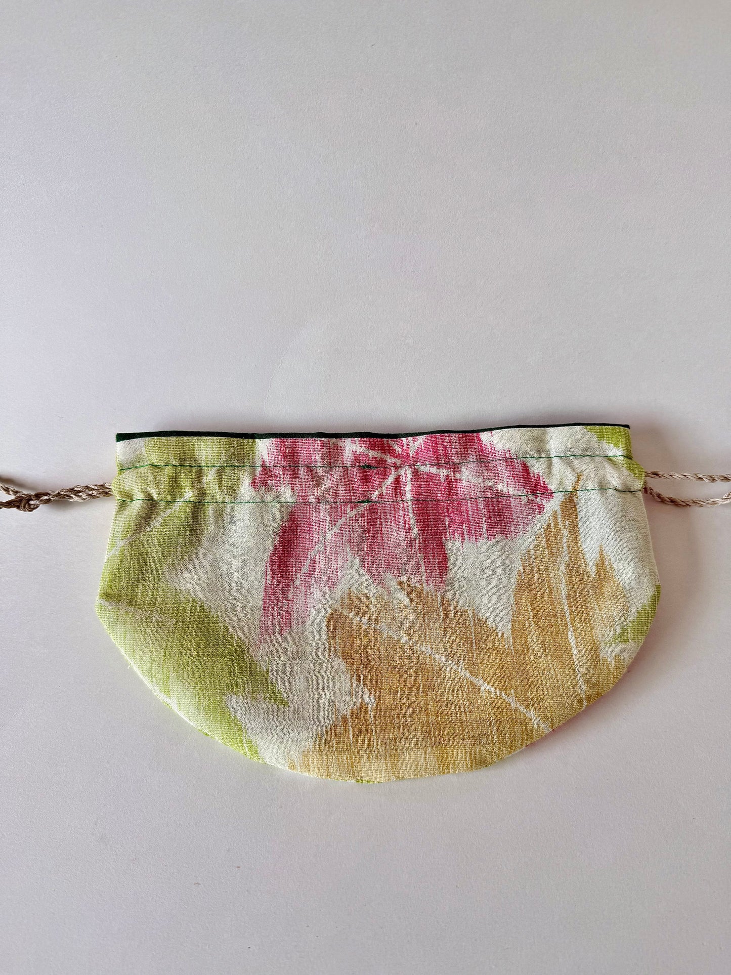 Back view of flat laying kimono silk pouch featuring yellow, red, and green maple leaf motifs in autumn hues
