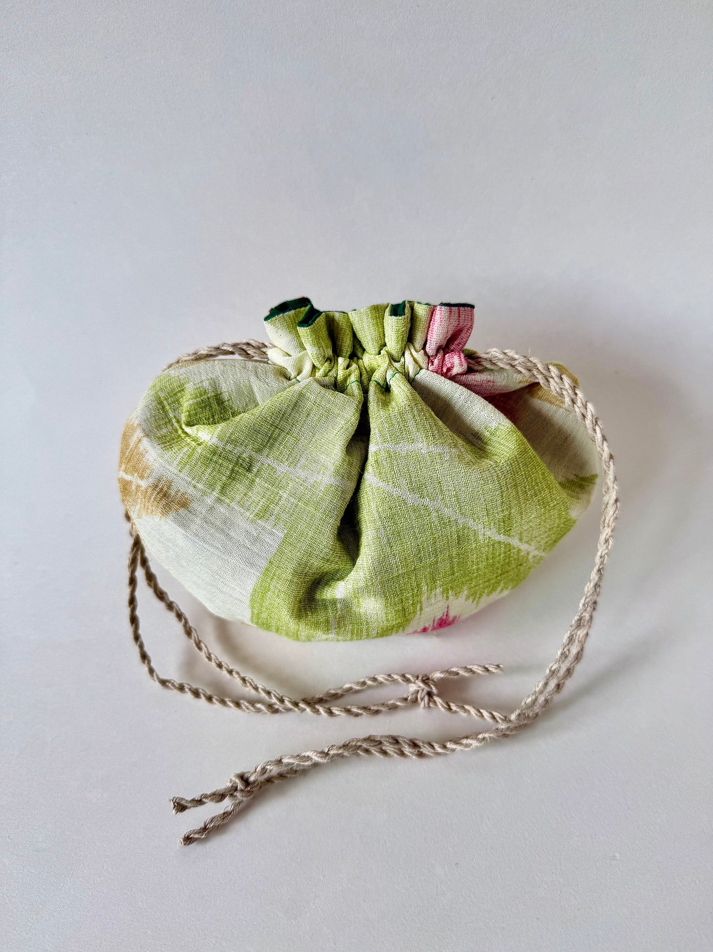 back view of off white kimono silk pouch with gree, yellow, and red momiji pattern, cinched closed with natural hemp drawstrings