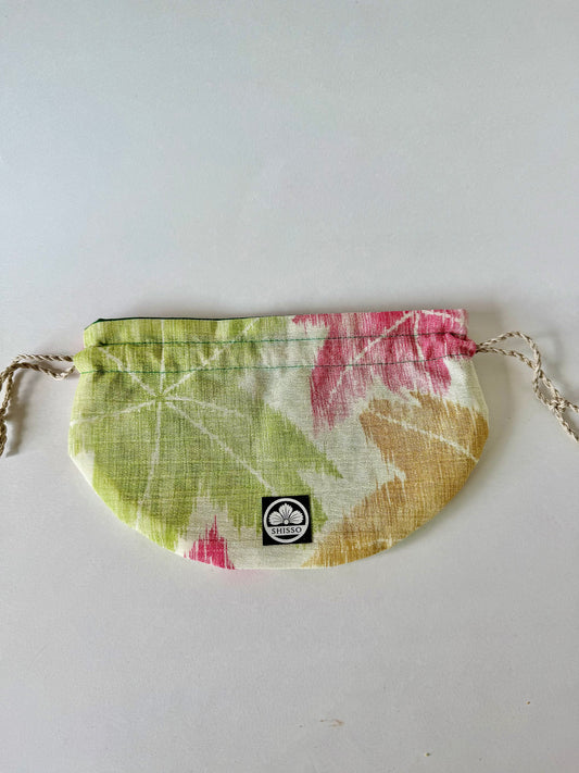 Flat laying off white kimono silk with green yellow, and red momiji pattern