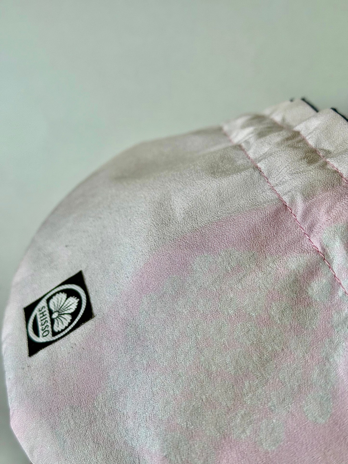 Close up front view of smooth pink kimono silk with darker silk accents and pink top stitching