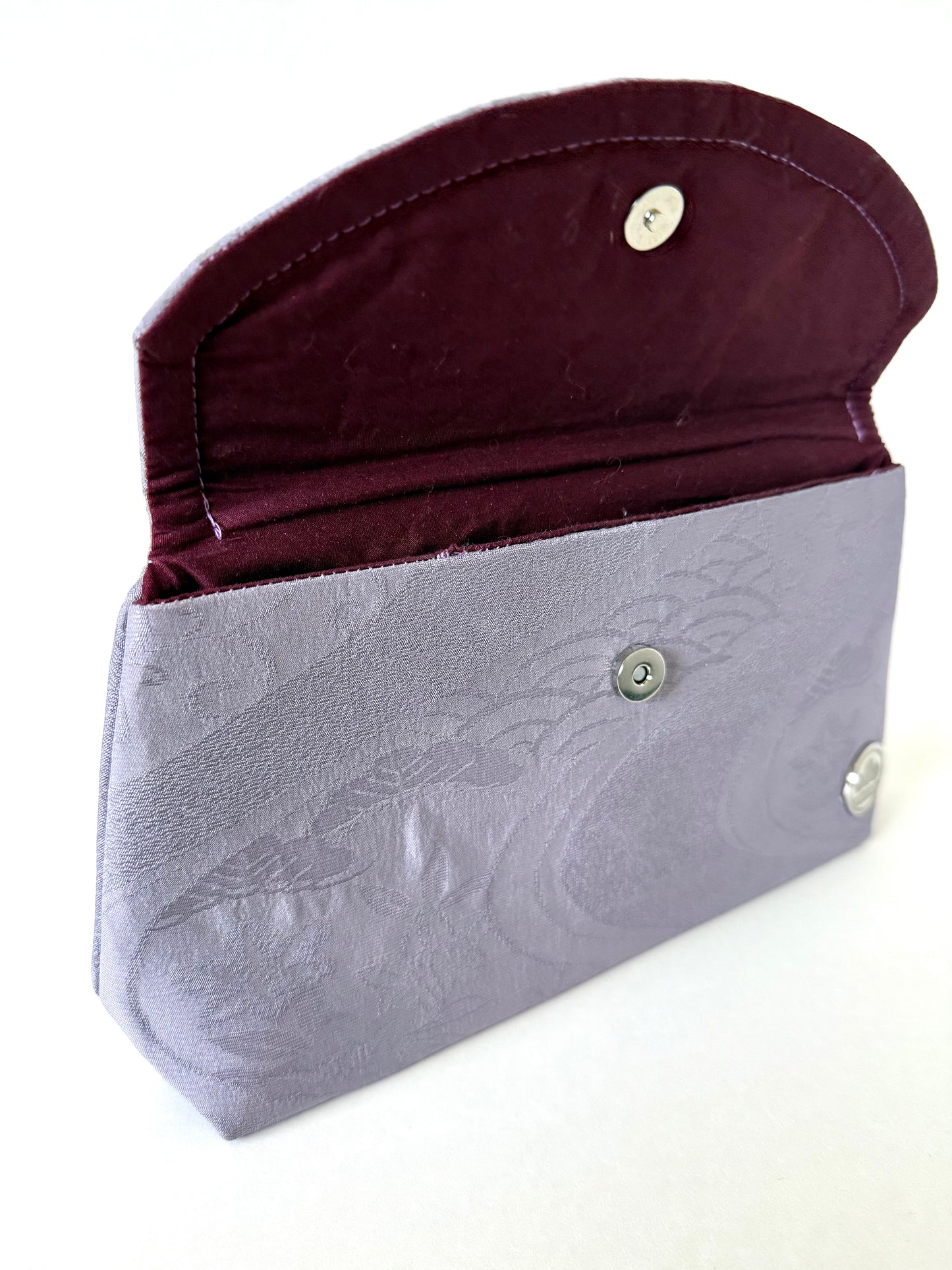 Opened flap of clutch bag showing hand stitched seam and subtle traditional wagara motifs
