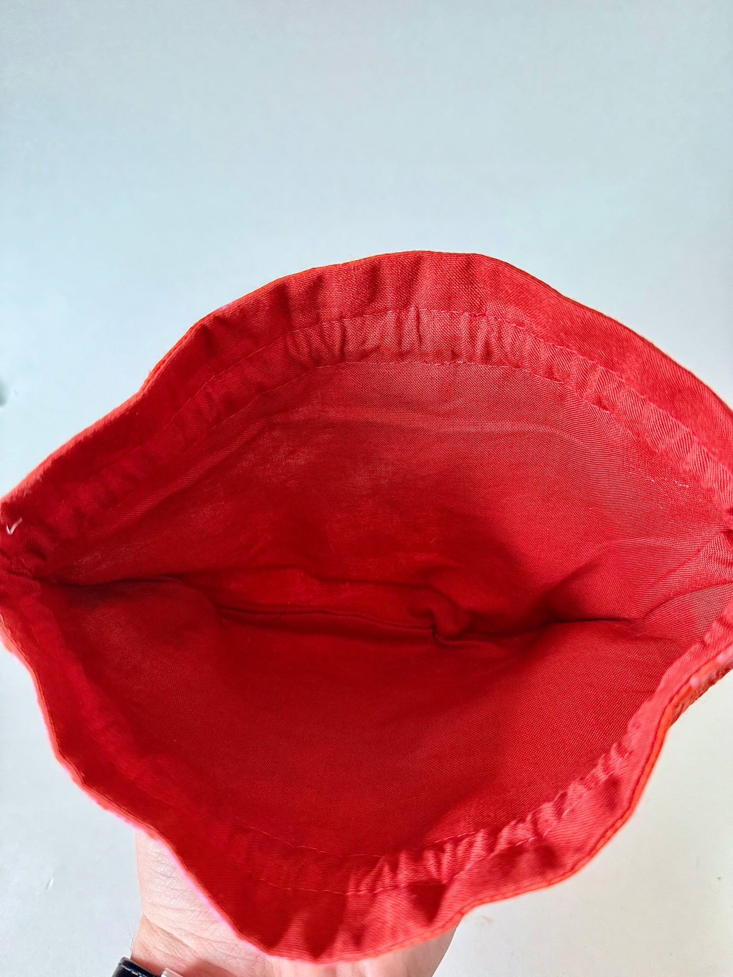 Top view of opened kimono silk drawstring pouch showing dark reddish orange 100% cotton interior lining