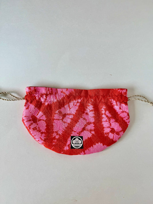 Reddish orange and pink shibori kimono silk drawstring bag with subtle sheen accents and natural hemp drawstrings