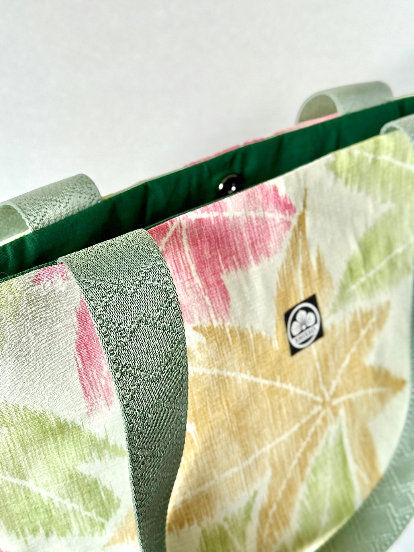 Front left view of kimono silk tote bag with green nylon handles featuring a geometrical pattern