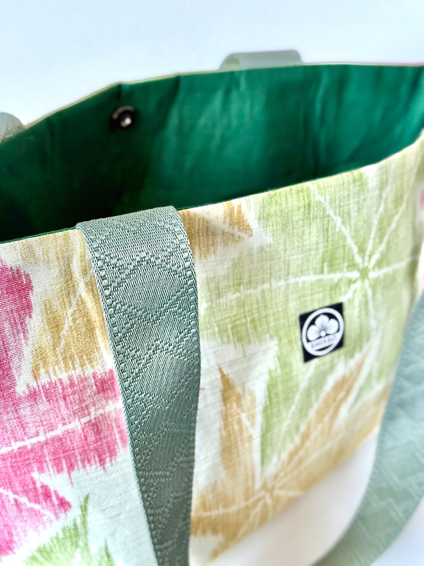 Close up view of deep sage green tote bag handles showing woven texture