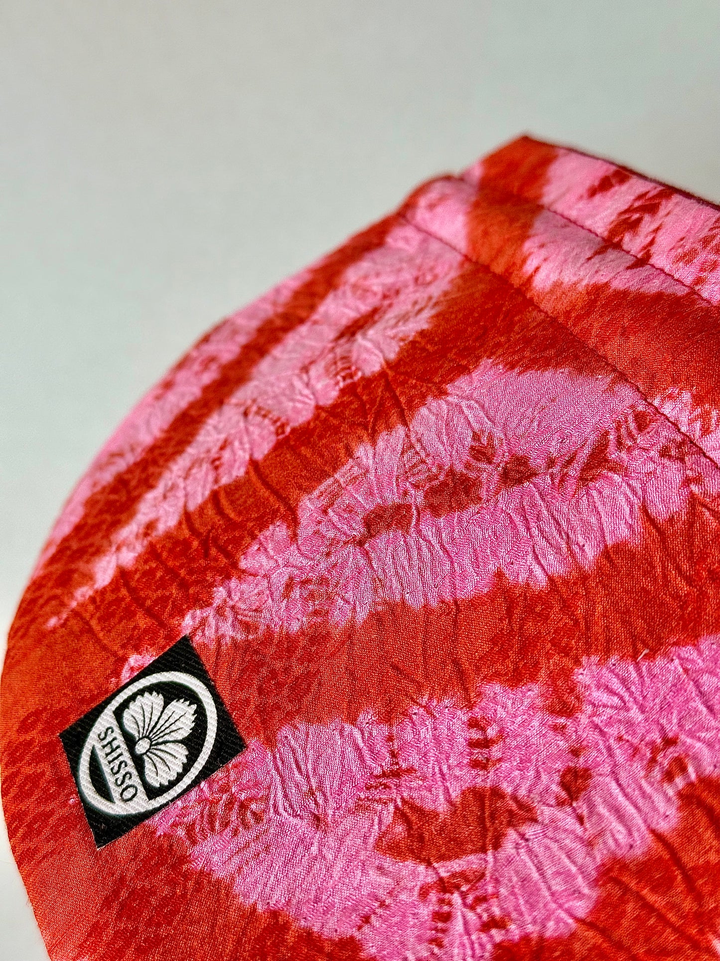 Close up view of red and pink kimono silk drawstring bag showing crepe and ripple texture in the fabric