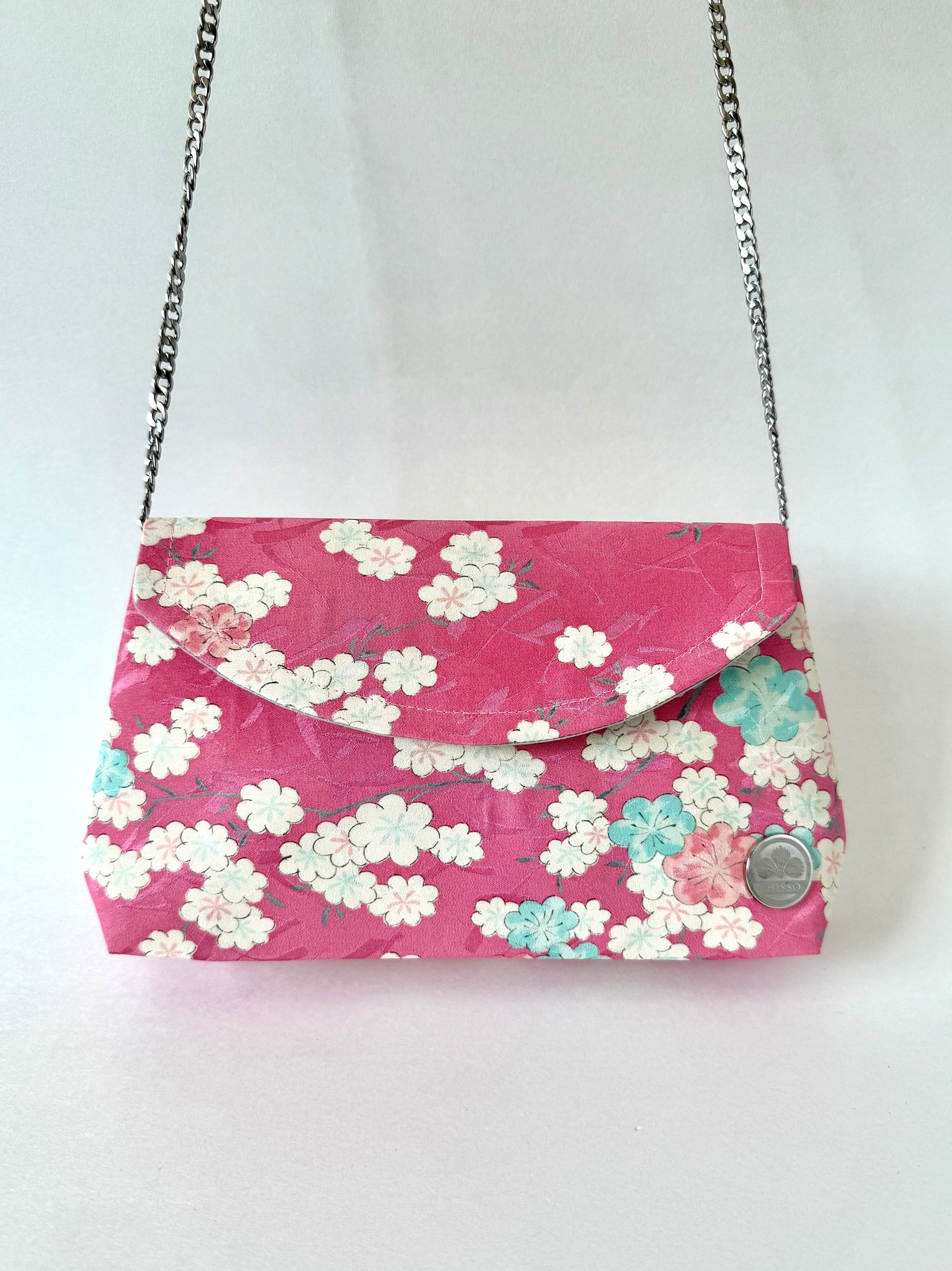 Pink kimono silk fold over clutch with multi colored cherry blossoms hanging from detachable chain strap