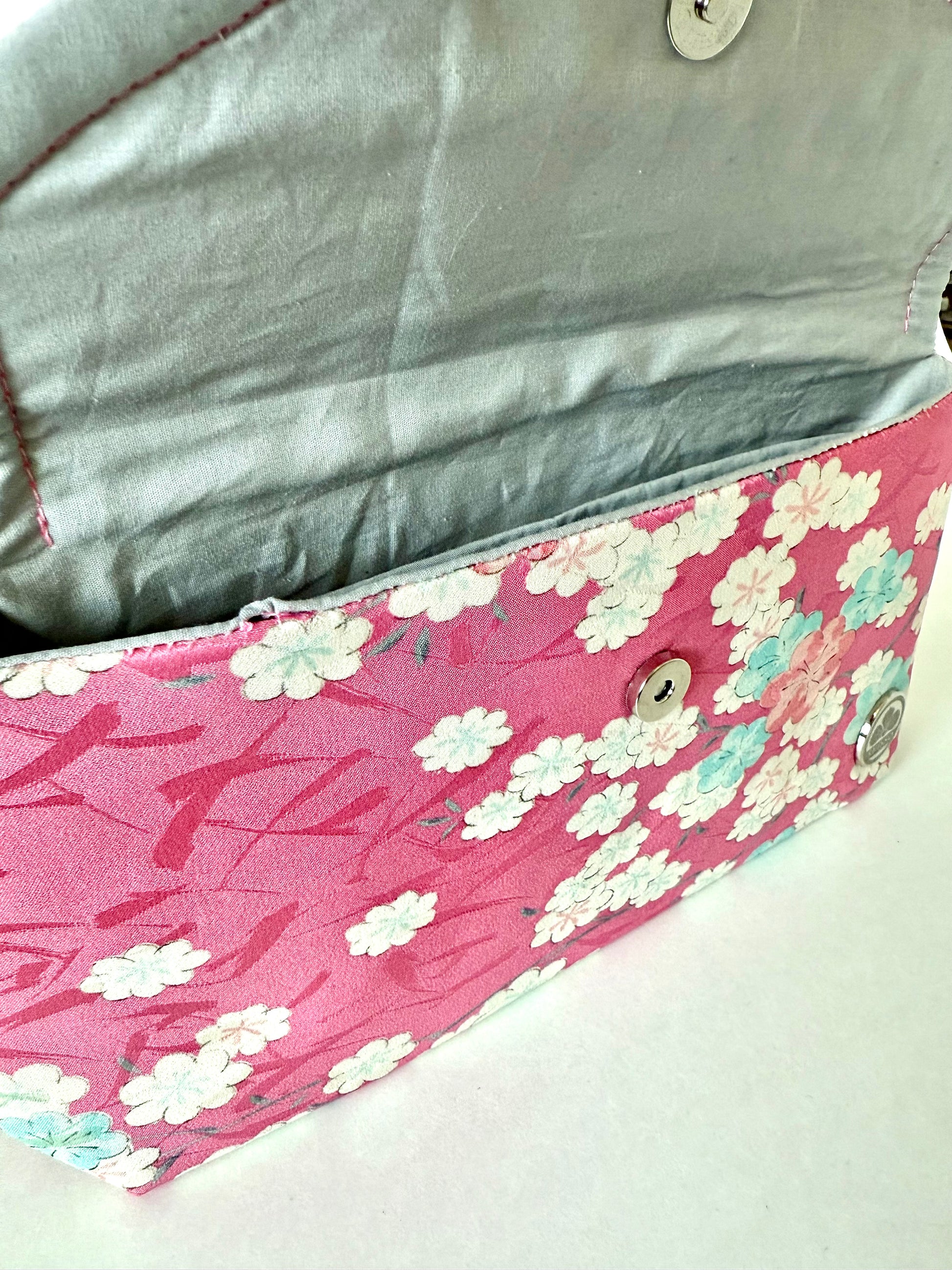 Close-up of hand stitched seam on vintage pink kimono silk with sakura motifs