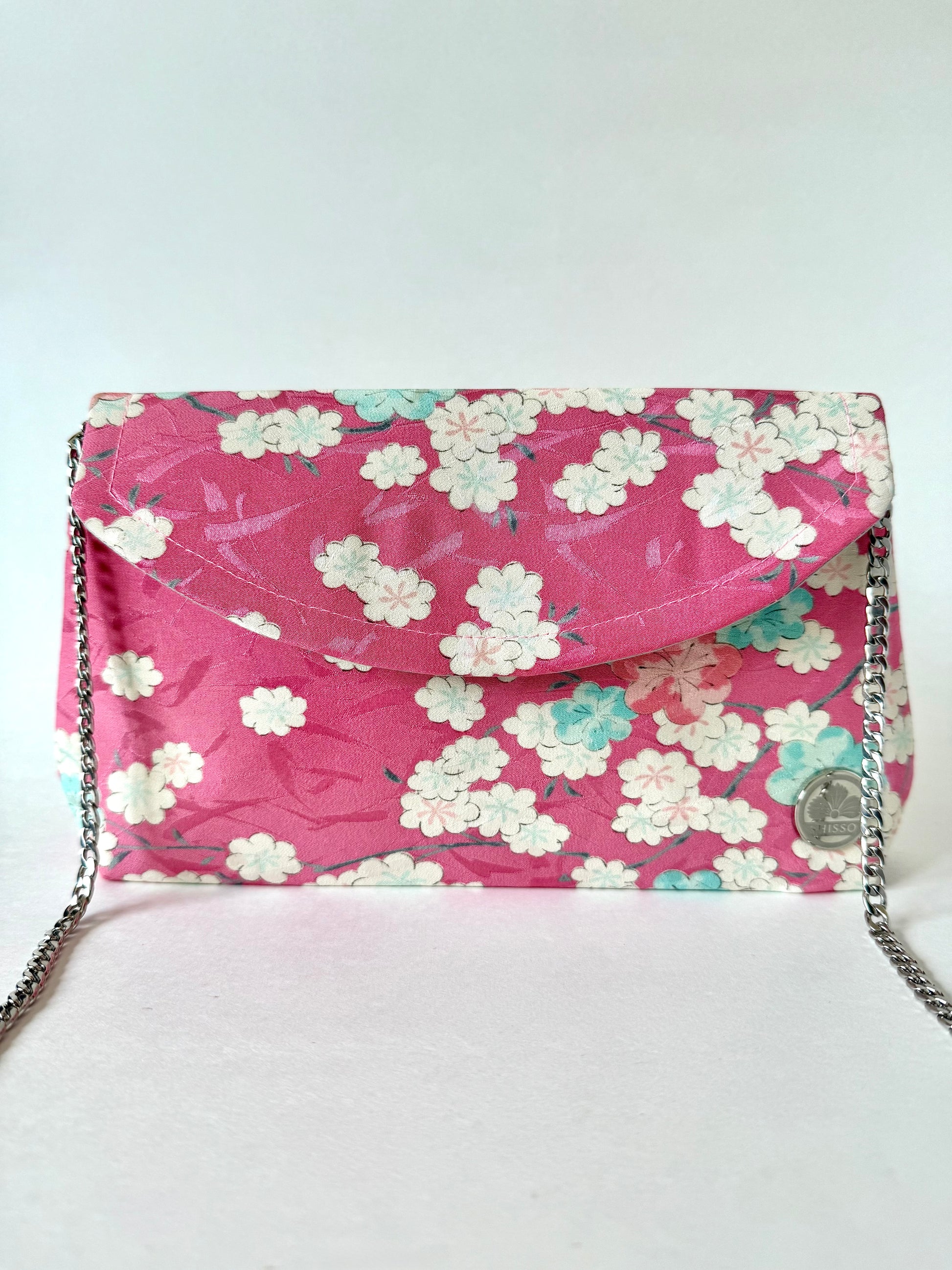 Pink kimono clutch with detachable 48-inch metal chain strap attached to hidden interior D-rings