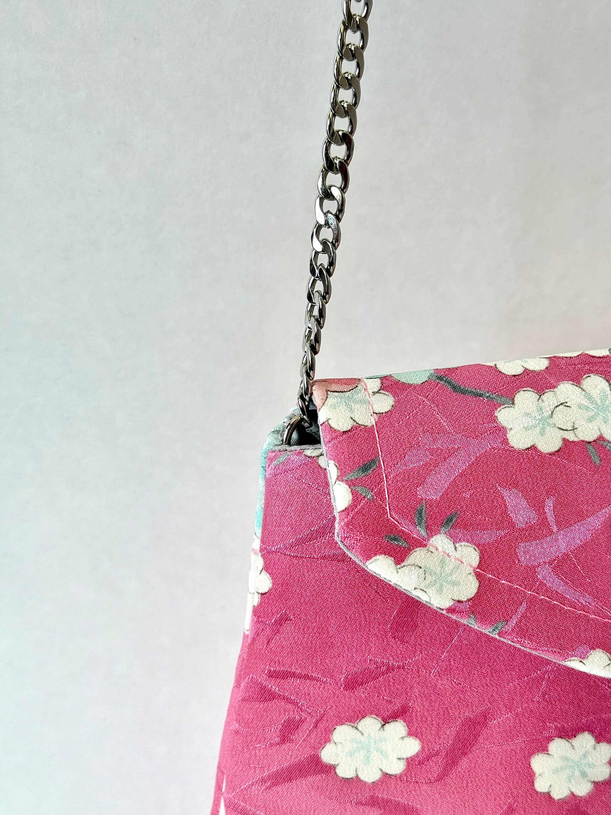Close up of chain strap connected to interior of pink kimono bag