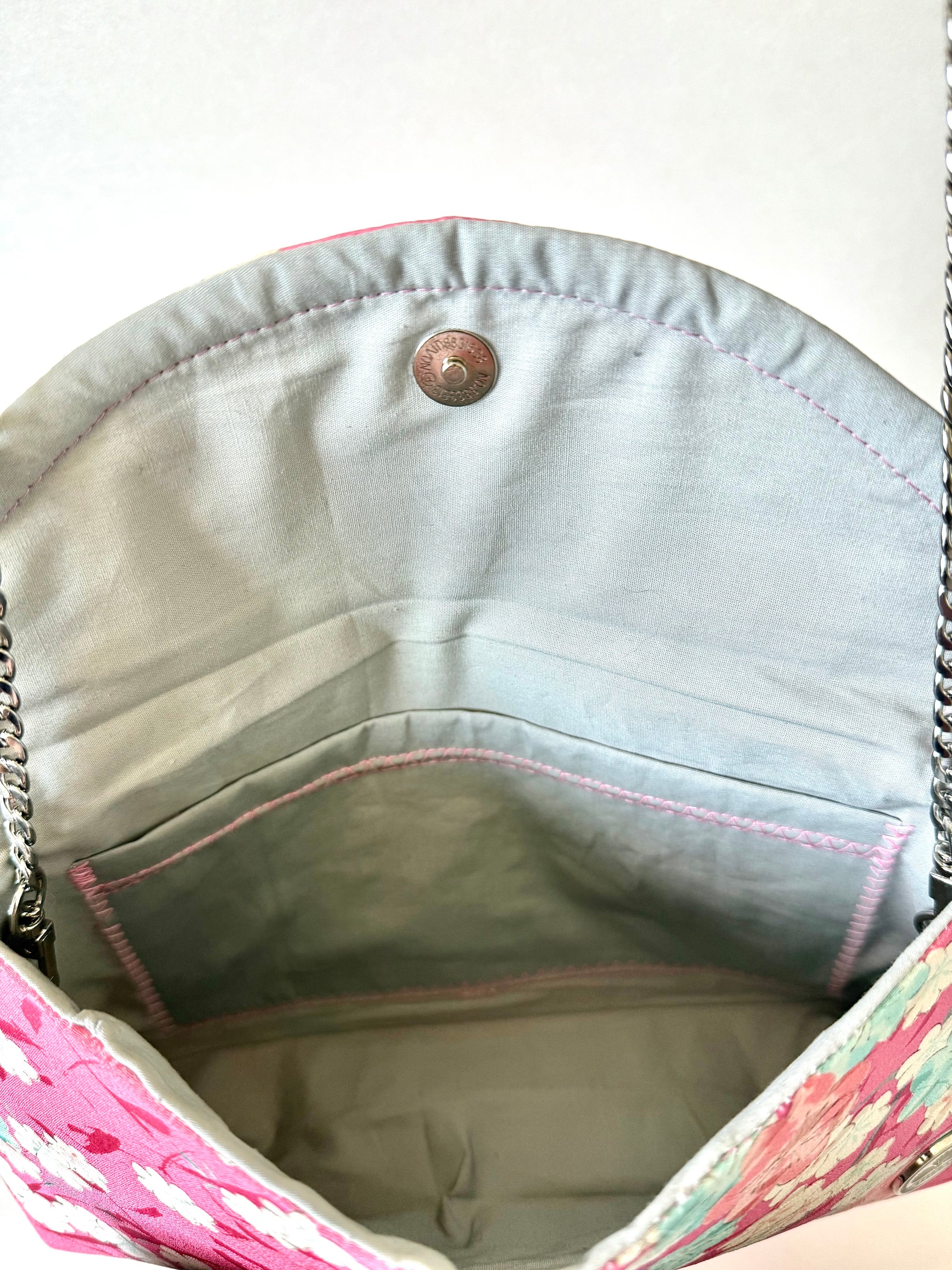 Inside view of the clutch showing silver cotton broadcloth lining, pink stitching, and interior phone pocket
