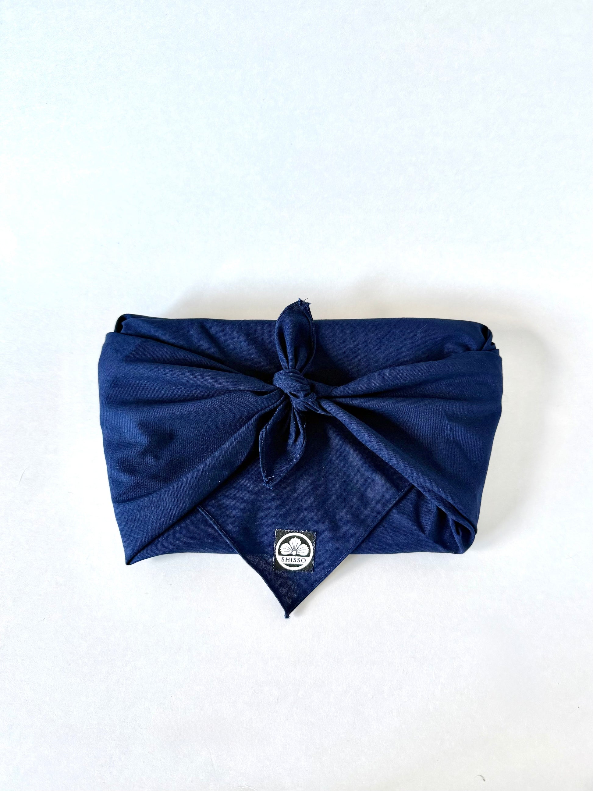 Shisso Clutch wrapped in traditional Japanese furoshiki cloth for sustainable packaging