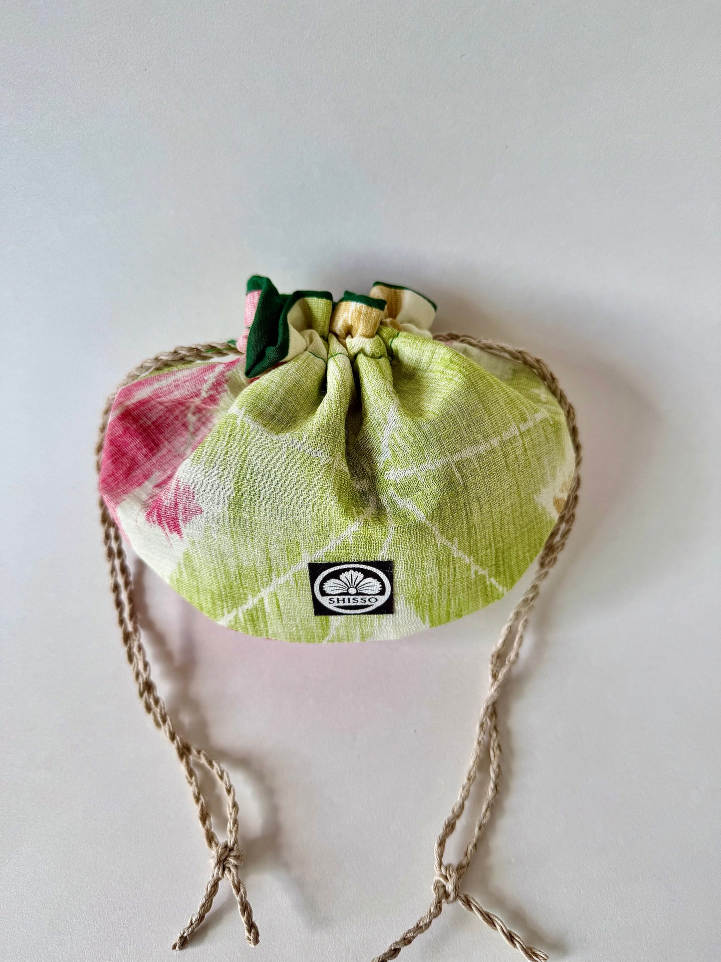 Cinched beige woven kimono silk drawstring bag with green and red Japanese maple leaf motifs