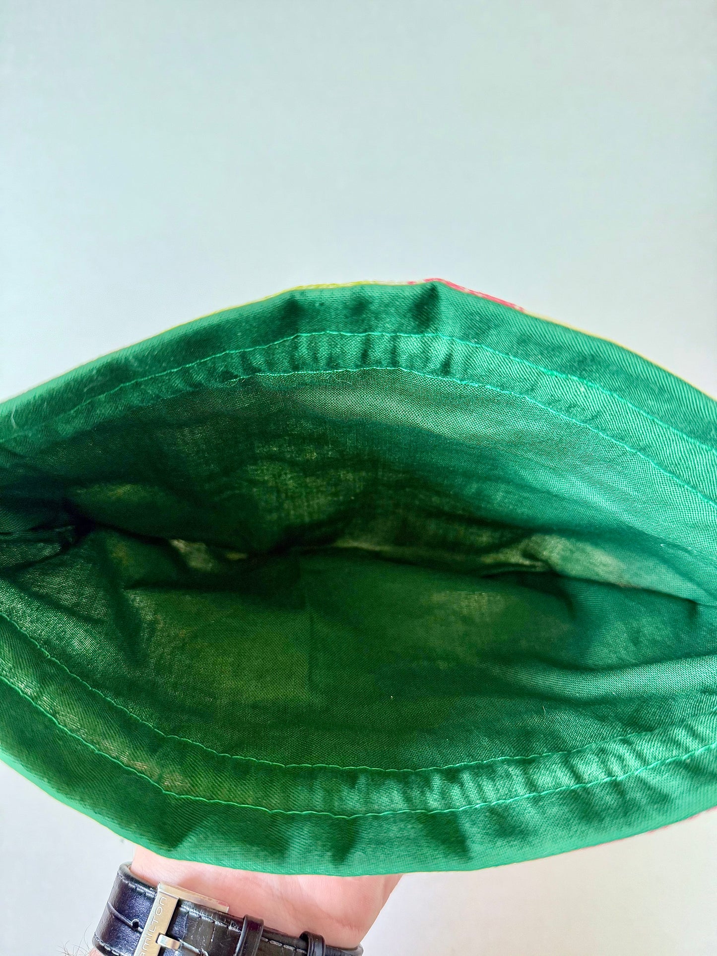 Interior view of kimono drawstring pouch showing dark green cotton lining and green top stitching