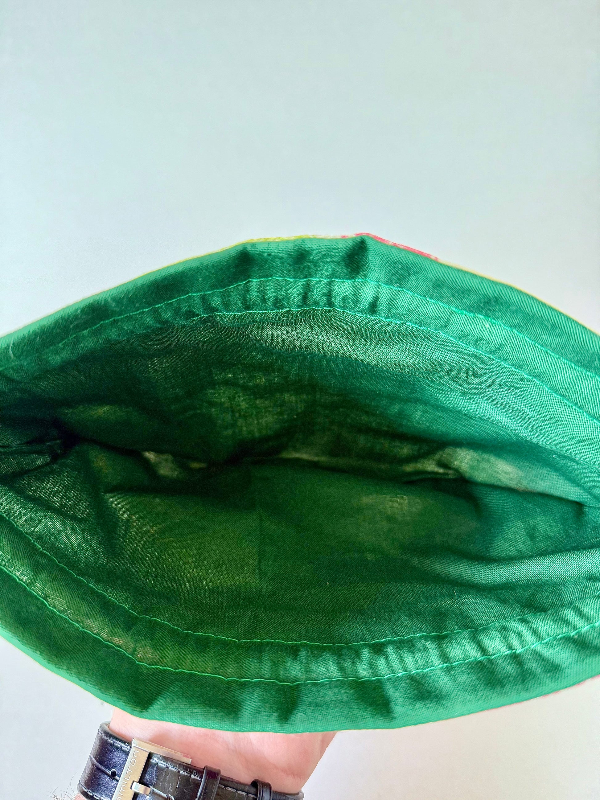 Interior view of kimono drawstring pouch showing dark green cotton lining and green top stitching