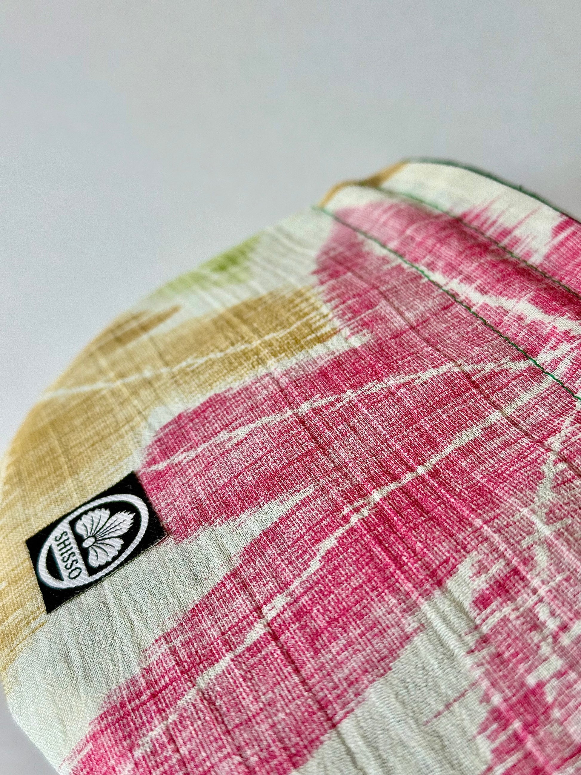 Close up front view of textured woven kimono silk with red and yellow momiji motifs