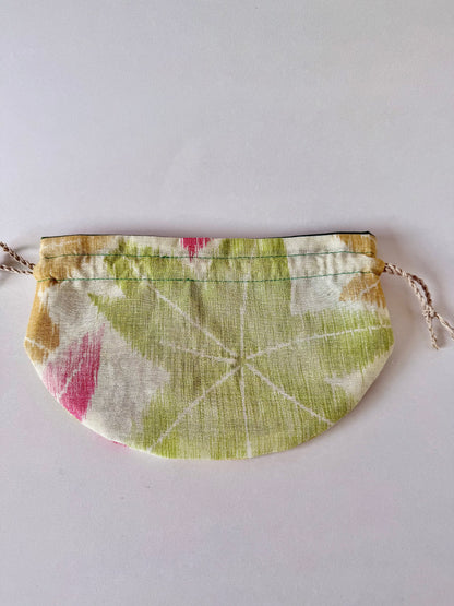 Backside view of flat laying woven kimono silk drawstring bag with large green momiji motif in the center