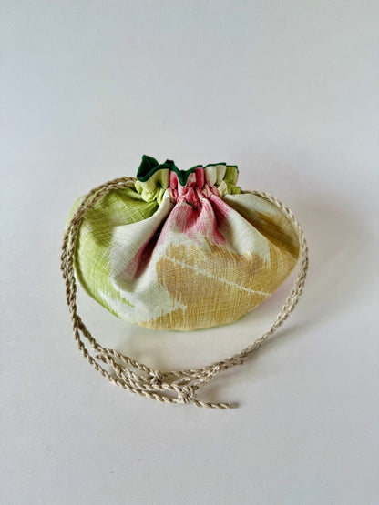 Backside view of beige kimono silk pouch featuring yellow, red, and green maple leaf motifs, cinched closed by hemp drawstrings