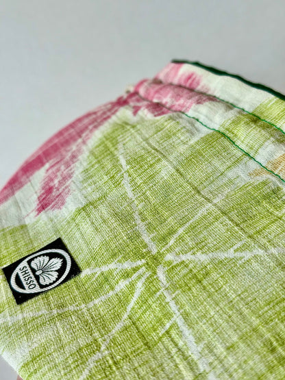 Front close up view of woven textured kimono silk featuring green and red maple leaf motifs in autumn hues