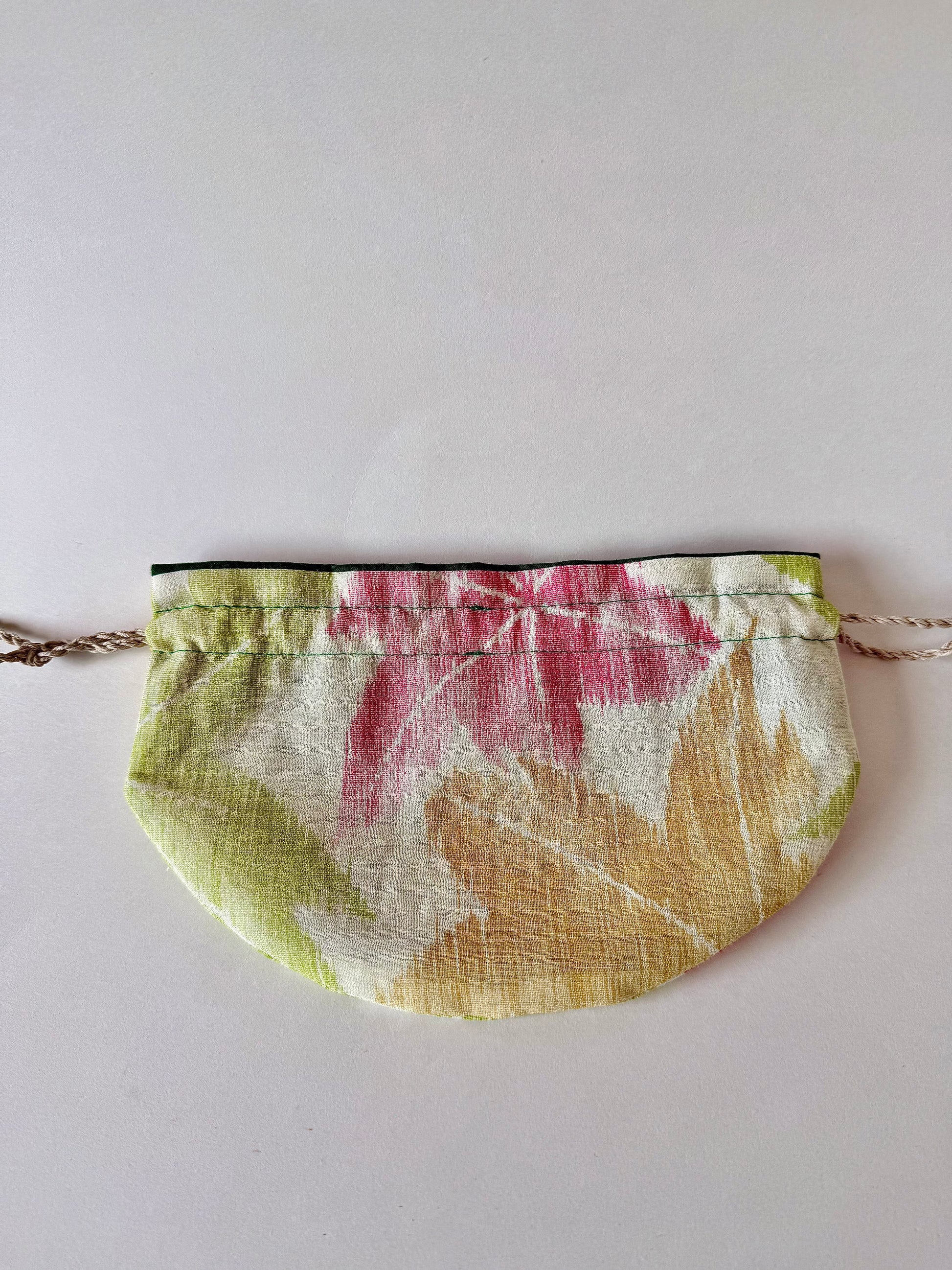 Back view of flat laying kimono silk pouch featuring yellow, red, and green maple leaf motifs in autumn hues