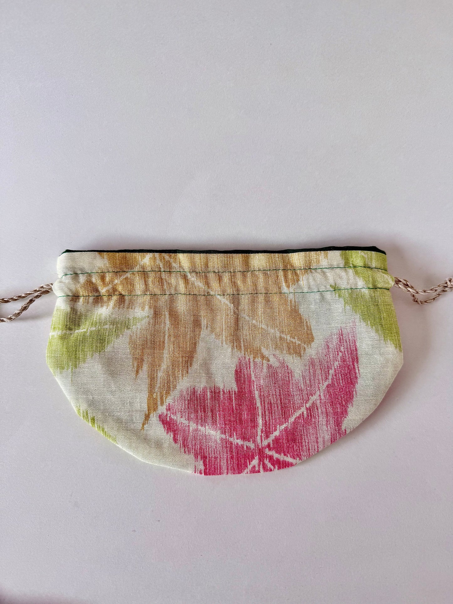 Flay laying woven kimono silk drawstring bag with yellow, green, and red Japanese maple leaf designs