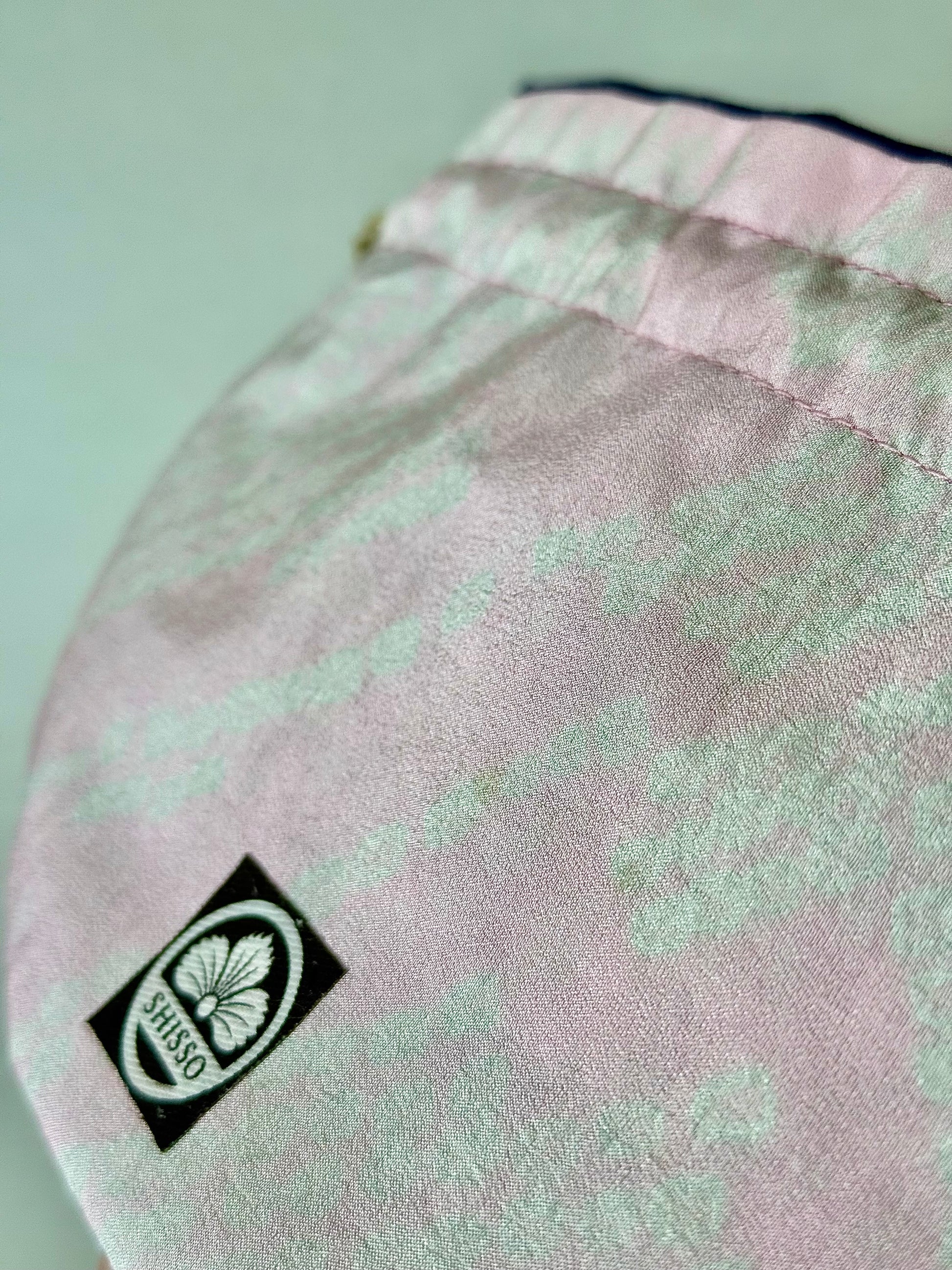 Close up view of smooth pink kimono silk texture and darker pink accents