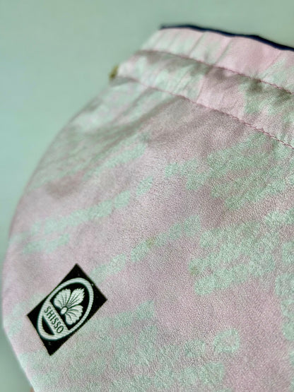 Close up view of smooth pink kimono silk texture and darker pink accents