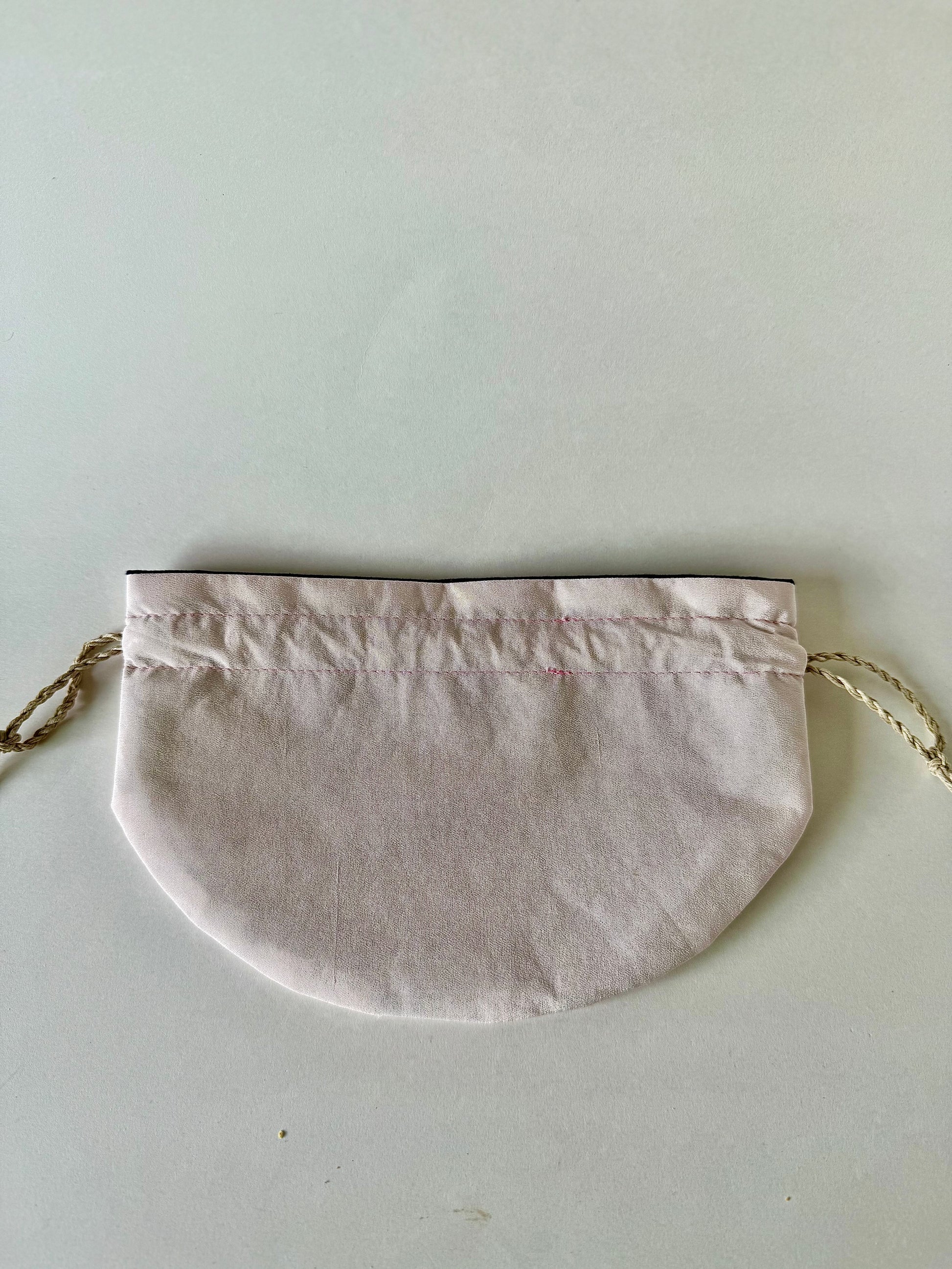 Back view of light blush pink kimono silk drawstring bag laying flat