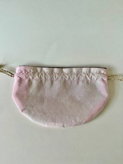 Backside of pink kimono silk drawstring bag laying flat with darker pink edges and natural hemp cords