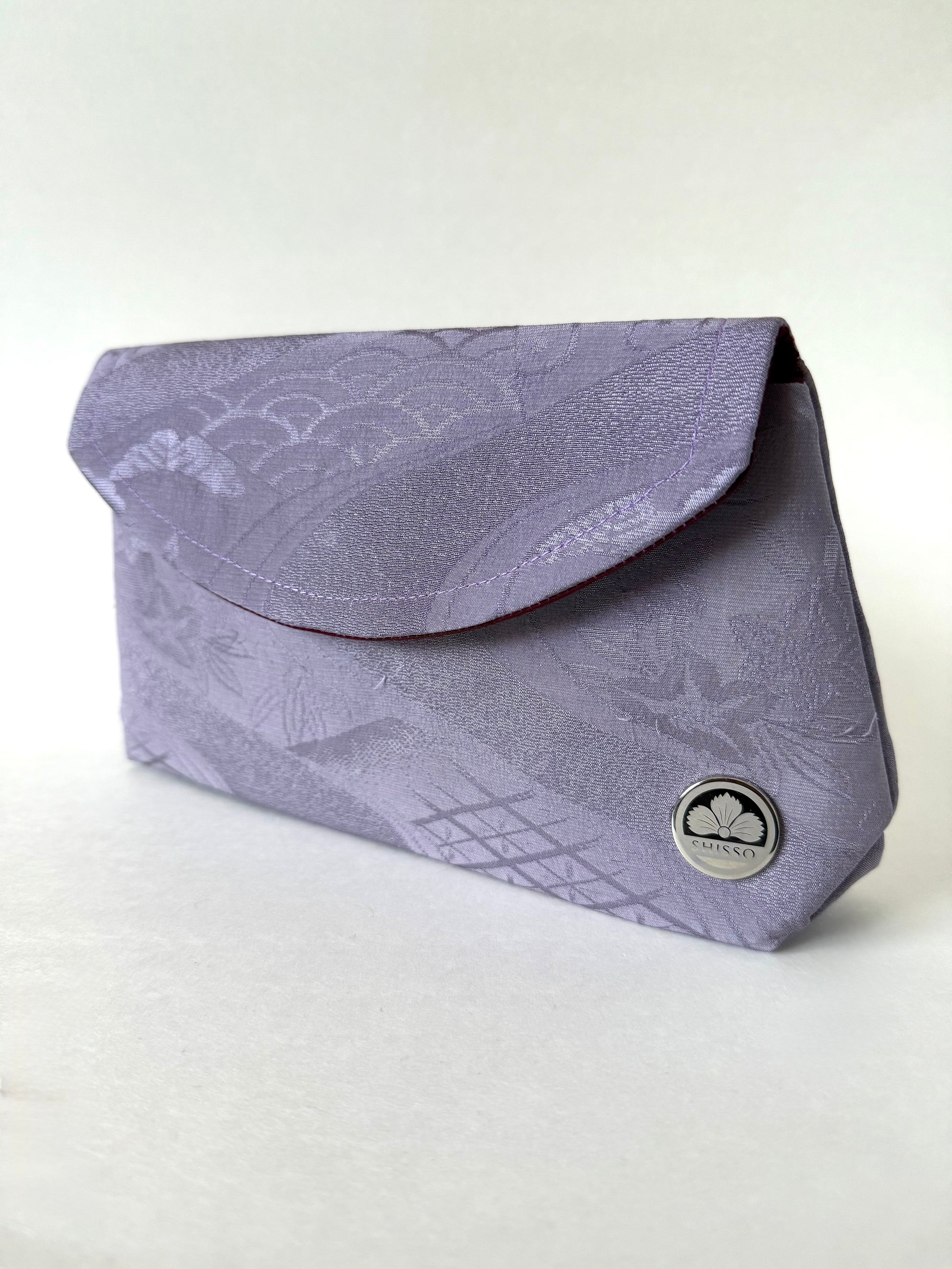 Front view of purple kimono silk fold over clutch featuring seigaiha and floral motifs