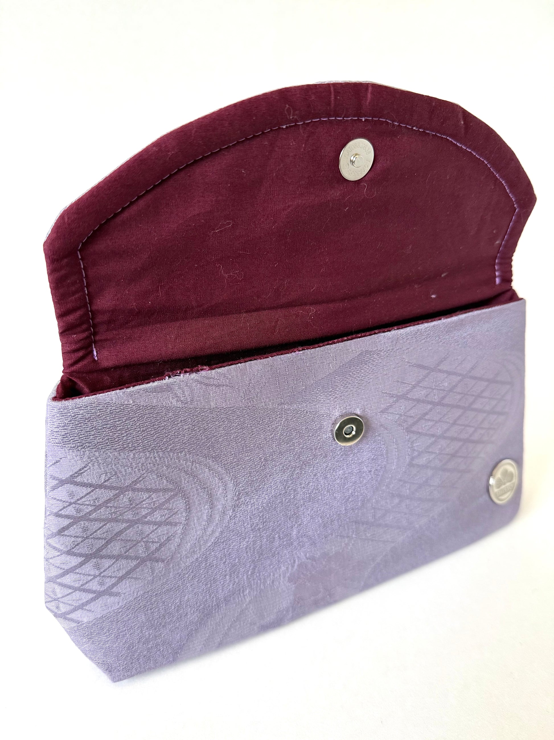 Close-up of hand stitched seam on purple vintage kimono Chirimen silk with geometric patterns and subtle sheen
