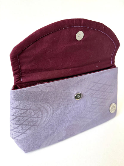 Close-up of hand stitched seam on purple vintage kimono Chirimen silk with geometric patterns and subtle sheen