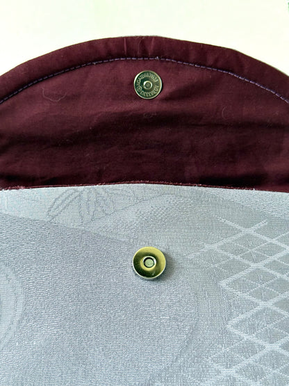 Silver colored magnetic closure on purple chirimen silk clutch with wine colored cotton broadcloth interior