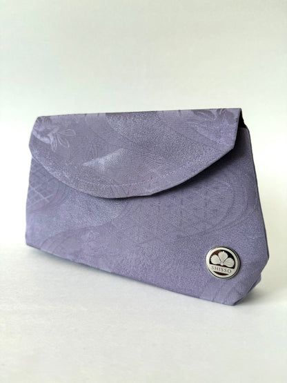 Angled view of purple kimono clutch showing crepe texture and minimalist silhouette