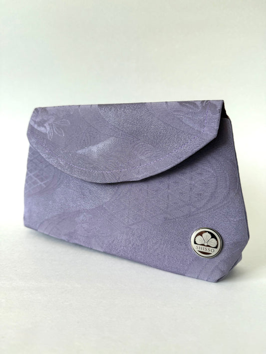 Angled view of purple kimono clutch showing crepe texture and minimalist silhouette