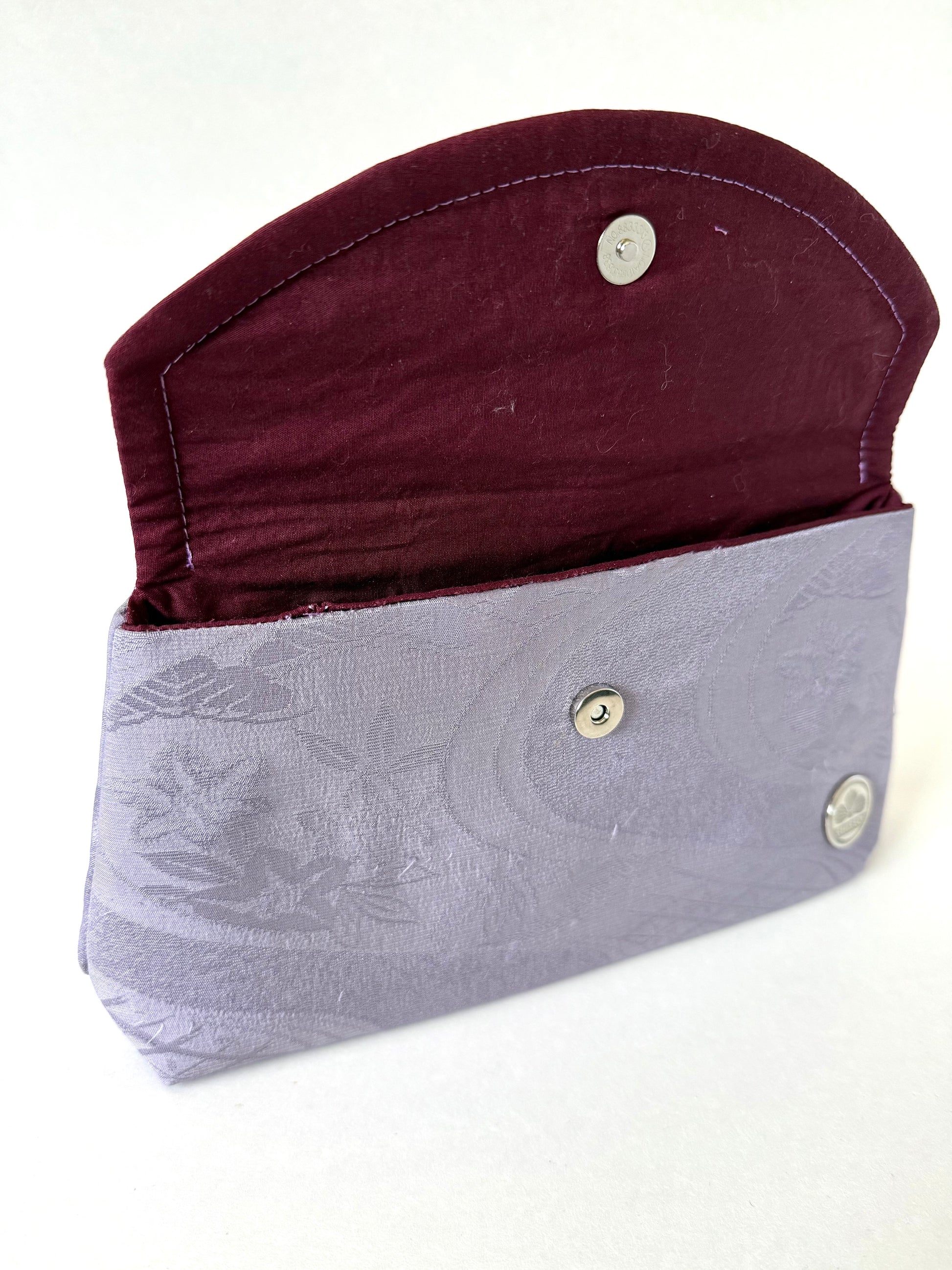 Purple kimono silk clutch bag with top flat opened showing a hand stitched seam and magnetic closure