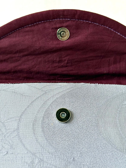 Close up of magnetic closure on the flap of handmade fold over clutch bag
