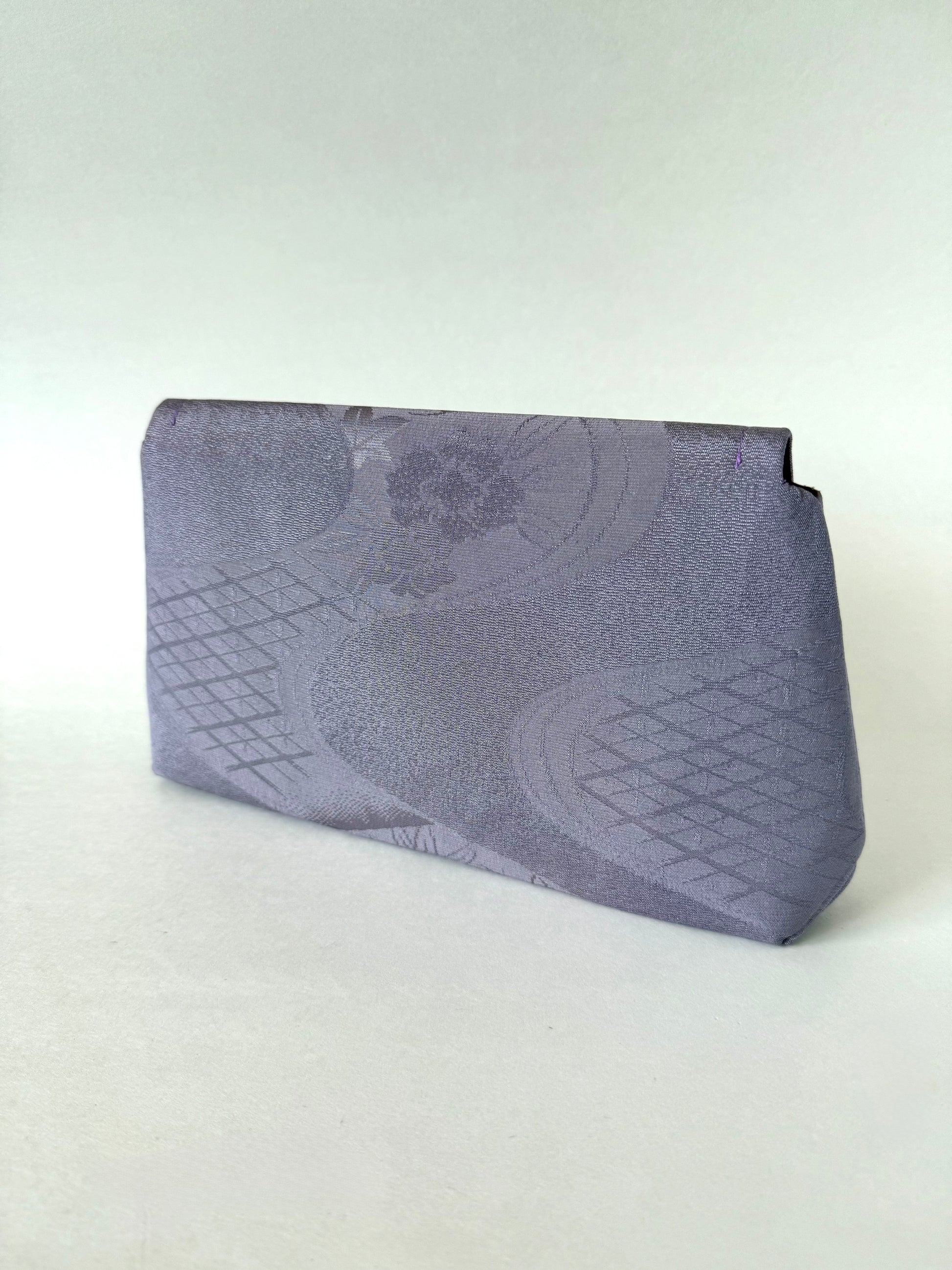 Back view of purple kimono silk clutch with flowing streams down the enter and geometric patterns on the edges