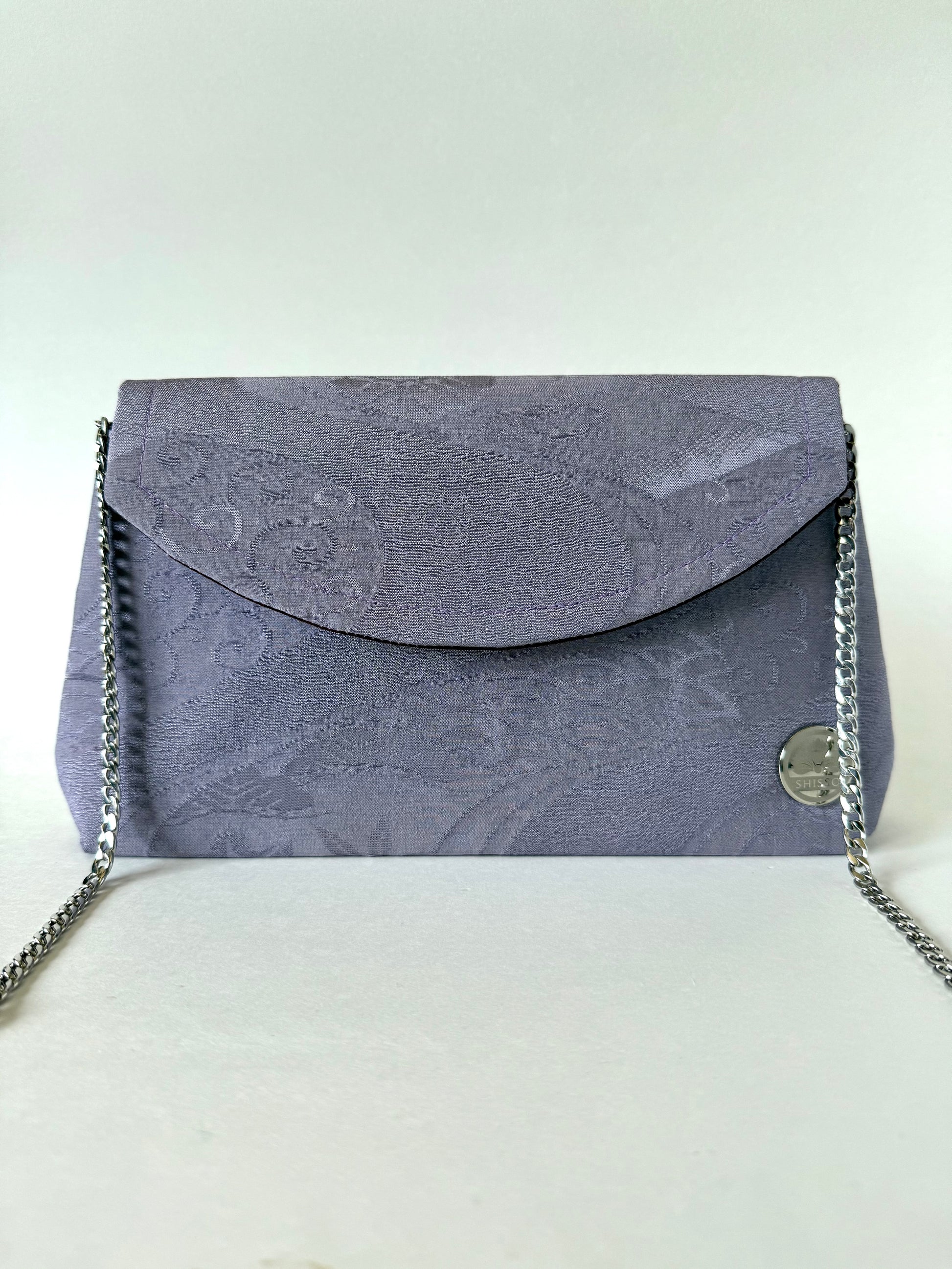 Front view of purple chirimen kimono silk foldover clutch bag with metal chain link strap