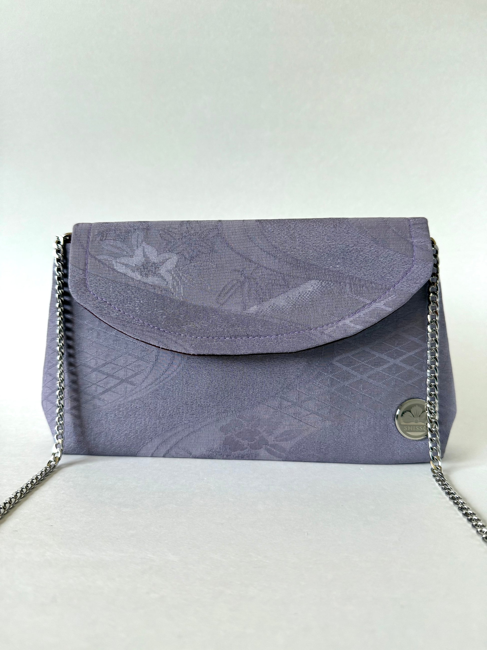 Front view of purple chirimen silk clutch with metal chain hanging from the the sides