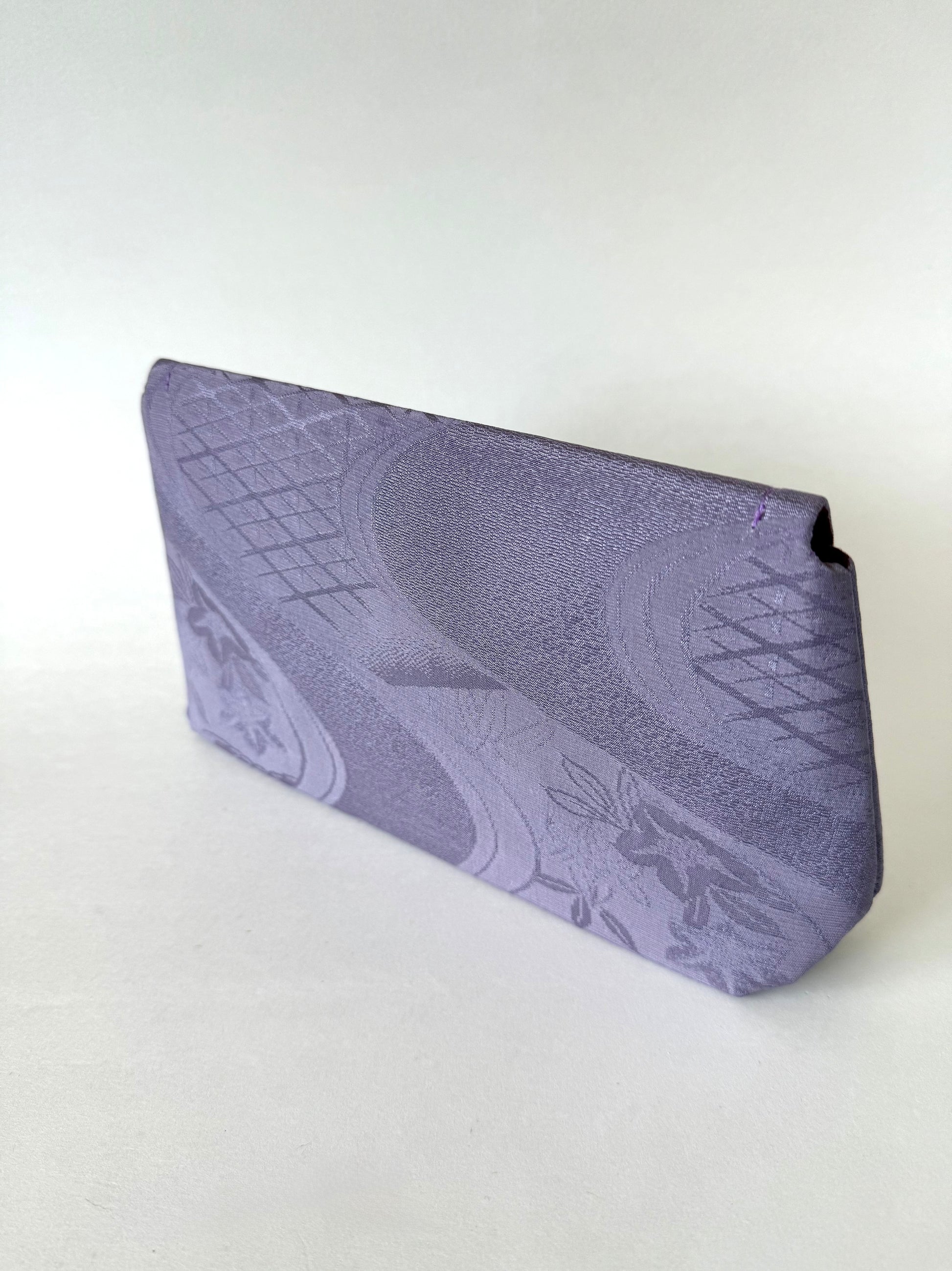 Back view of purple kimono silk clutch with floral and diamond patterns on the corners 