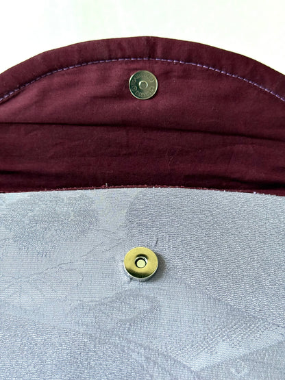 Close up of metal magnetic closure on purple kimono silk fold-over clutch