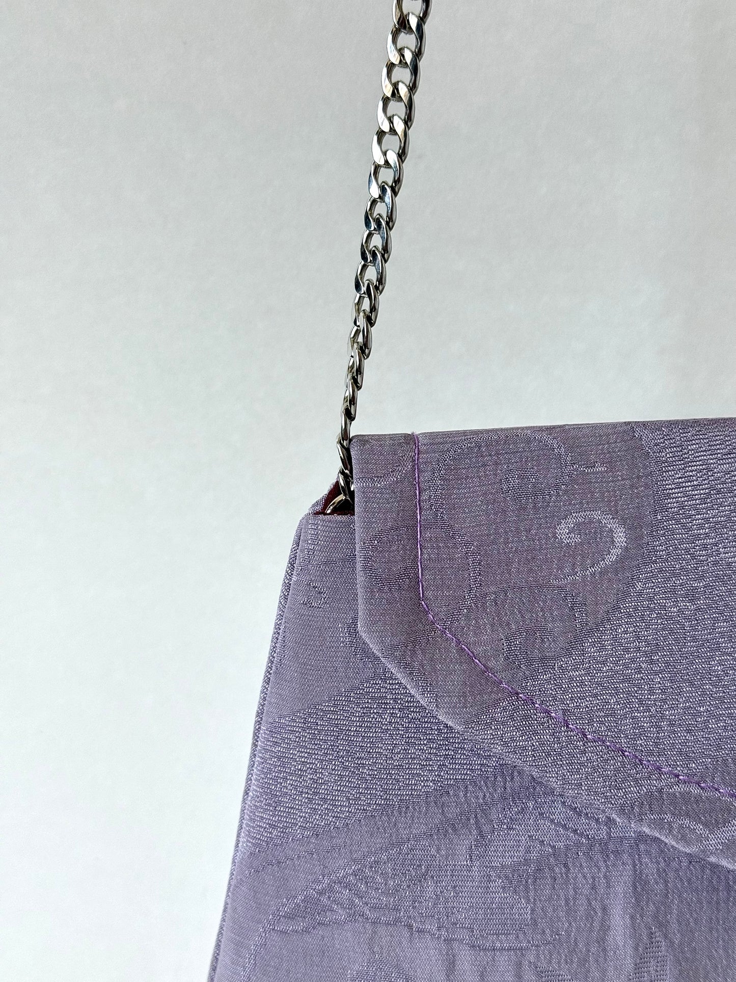 Thing metal chain strap connected to the interior corned of purple kimono chirmen silk clutch bag