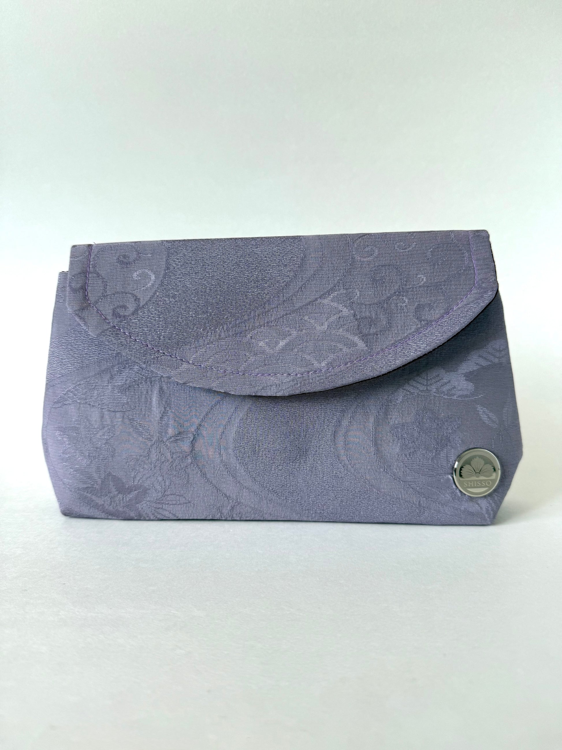 Frontal view of purple kimono chirimen silk clutch bag featuring wagara and river motifs with slight sheen