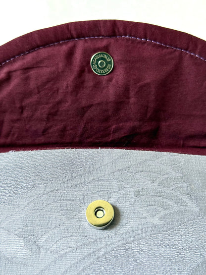 Close up view of magnetic closure over seigaiha motif and under hand stitched seam