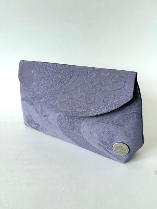 Front angled view of purple kimono chirimen silk clutch bag featuring traditional wagara motifs