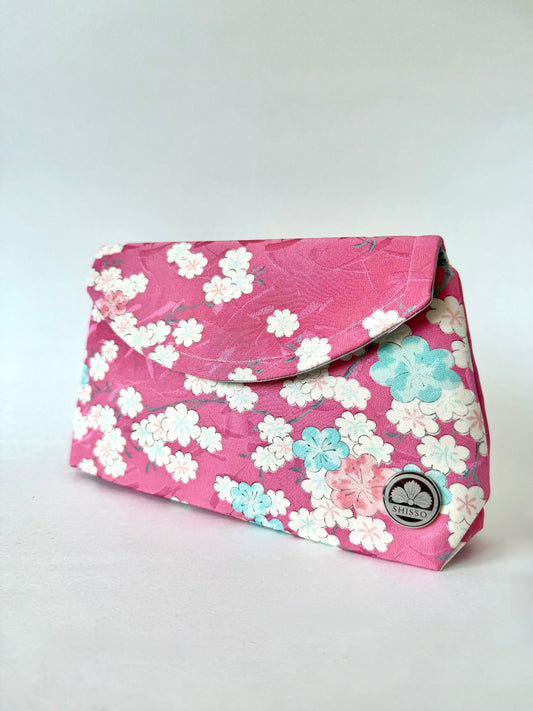 Front angled view of pink kimono silk clutch bag with cherry blossoms