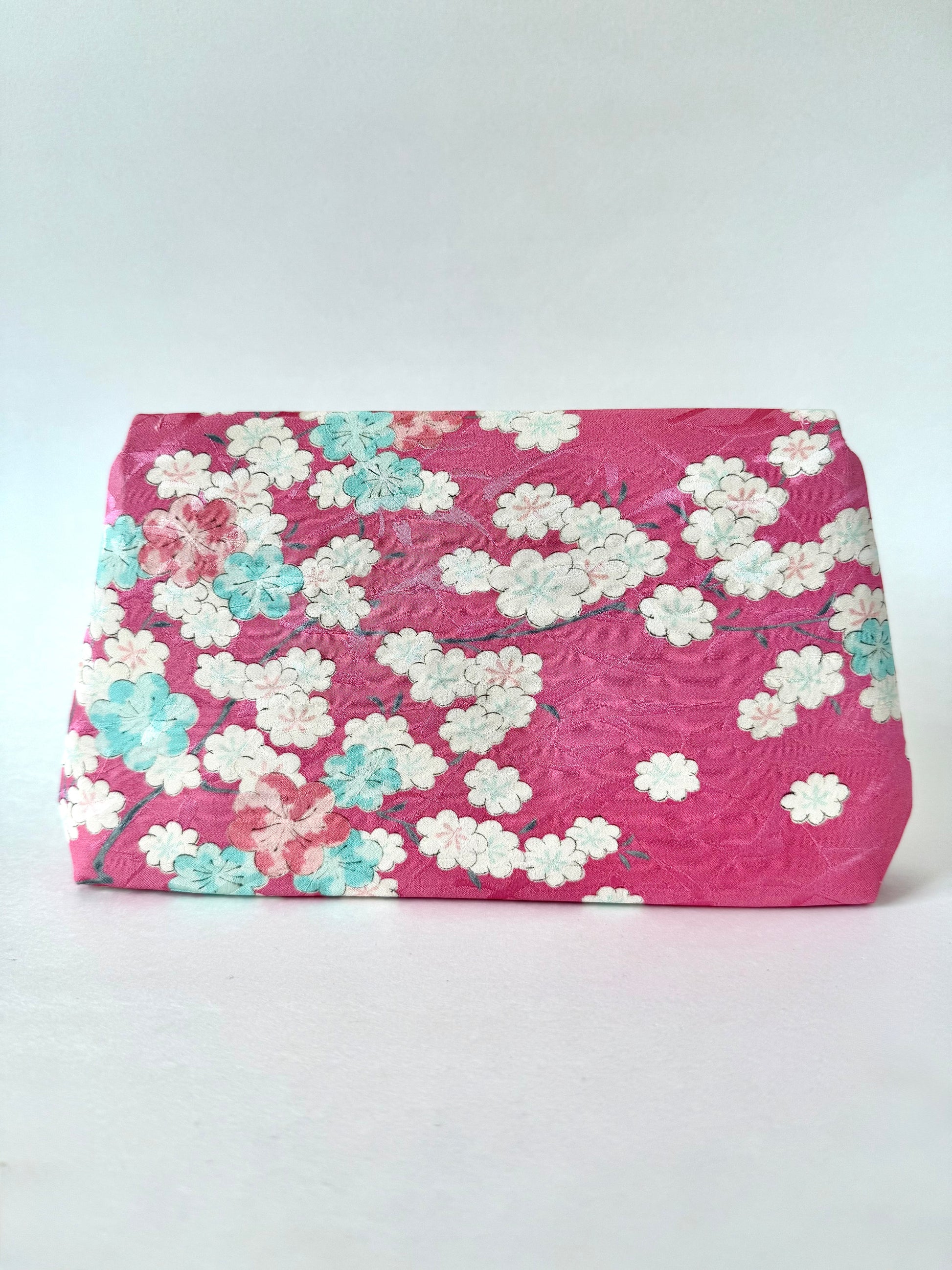 Back view of pink kimono fabric clutch bag with cherry blossoms blooming on branches